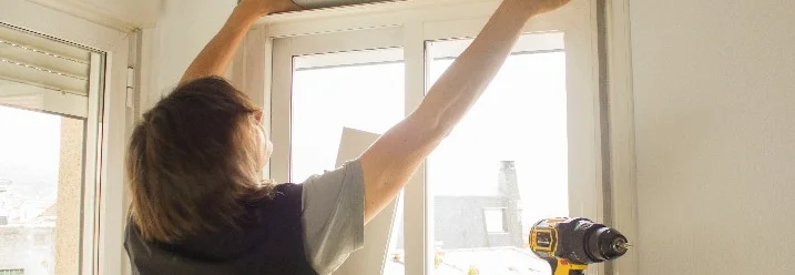 Person montiert Rolladenkasten mit Akkuschrauber.